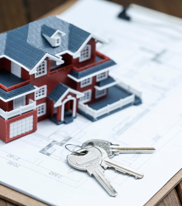 Villa house model, key and drawing on retro desktop (real estate sale concept)